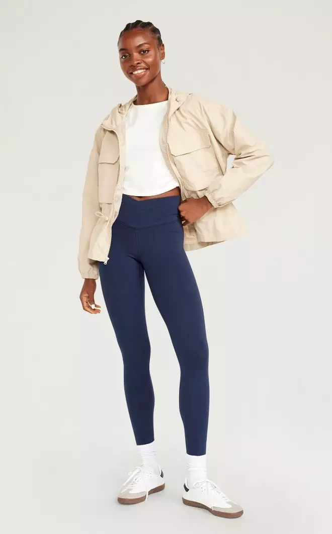 A female models wears a cargo-style activewear zip-up jacket