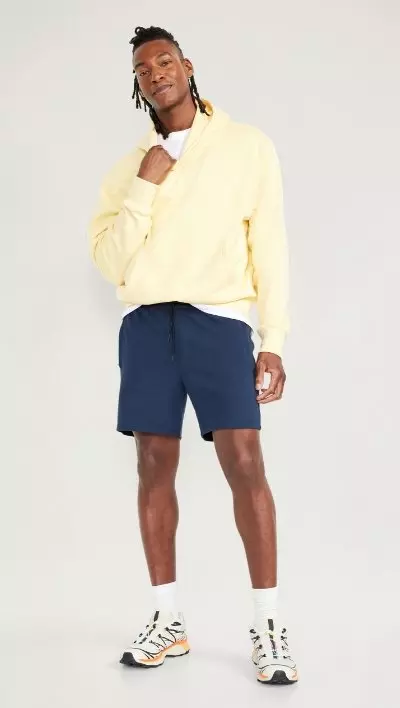 A male model wears a pair of blue StretchTech Water-Repellent Chino Shorts for Men -- 9-inch inseam