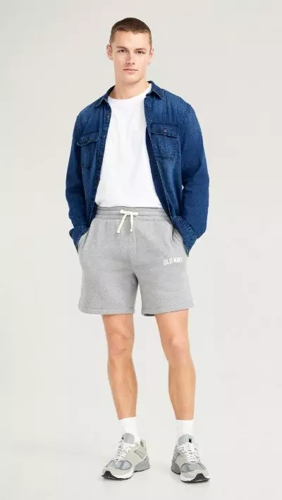 A male model wears a pair of grey fleece logo shorts