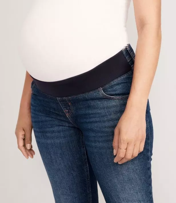 A pregnant model wearing below the bump maternity jeans.