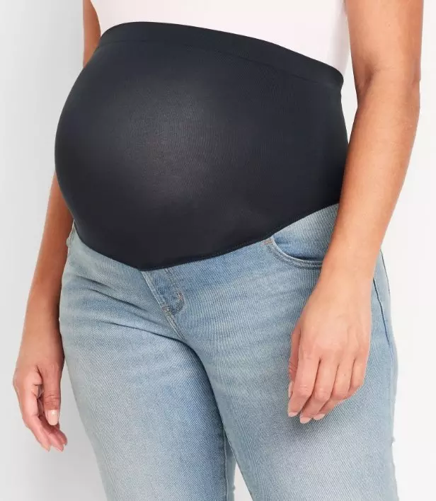 A pregnant model wearing over the bump maternity jeans.