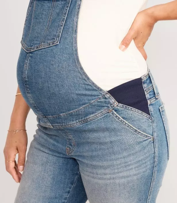 A pregnant model wearing maternity side-panel OG straight jean overalls.