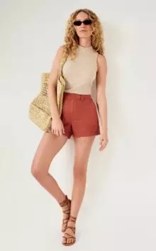 A female model wearing bronze colored High-Waisted OGC Chino Shorts -- 3.5-inch inseam