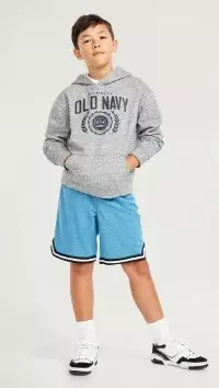 A boy dressed in blue active jersey style shorts and an Old Navy sweatshirt.