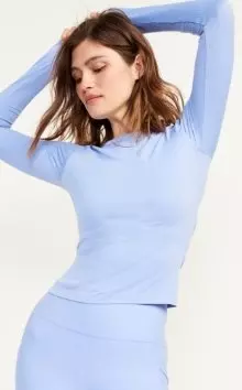 A female model wearing a blue long-sleeve activewear top.