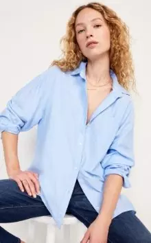 Une femme porte un chemisier bleu.