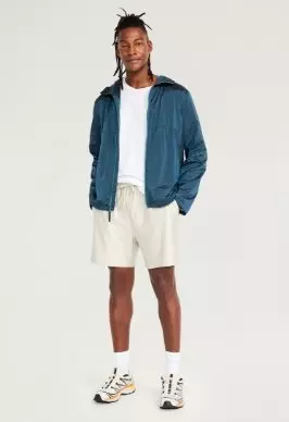 A male model wears a hooded activewear jacket.