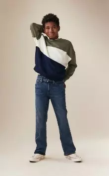 A male model wearing boot-cut built-in flex jean and striped crew neck softest long sleeve tee.