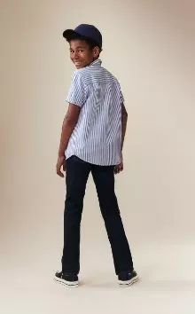 A young model wearing dark stretch jeans.
