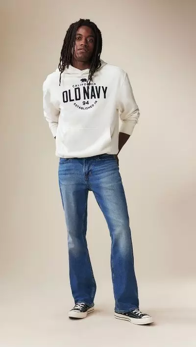A male model wearing boot-cut jeans and an Old Navy logo hoodie.