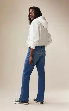 A male model wearing boot-cut jeans.