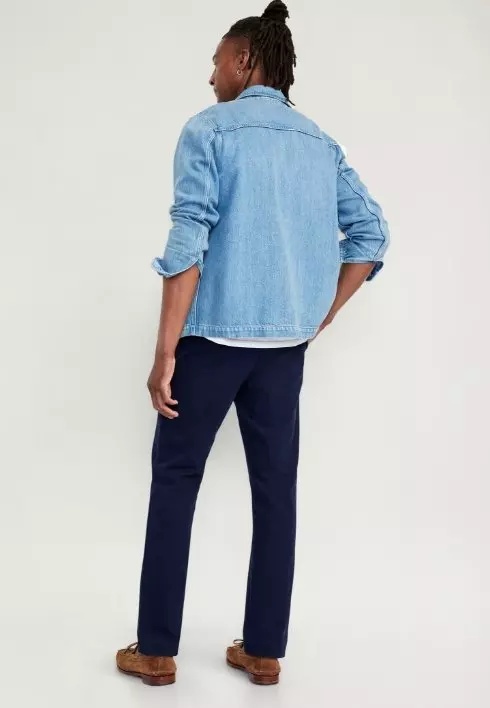 A male model wears straight leg black pants. 