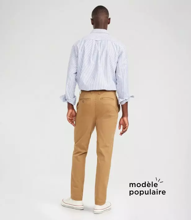 Un homme porte un pantalon chino en coton doux au fini foncé.