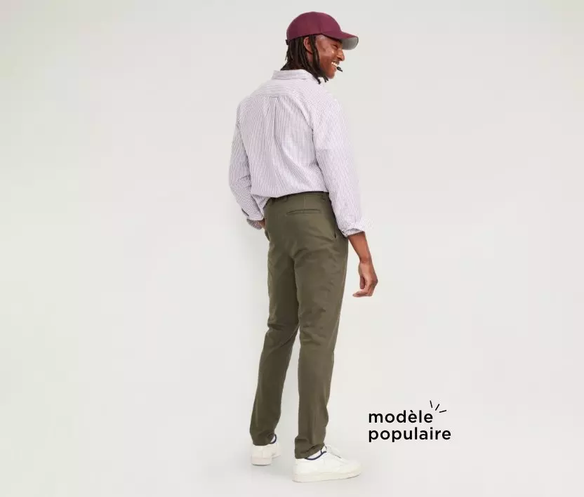 Un homme porte un pantalon chino en coton doux au fini foncé.