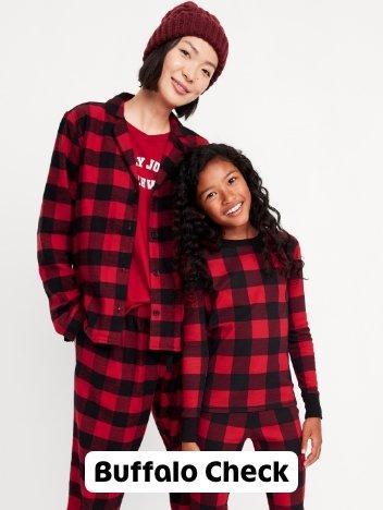 A mother and daughter in buffalo check pj onesies.