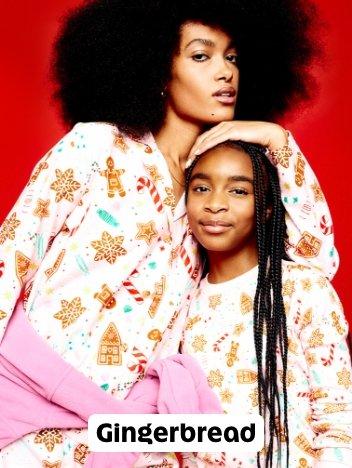 A woman and child in matching gingerbread print pajama sets.