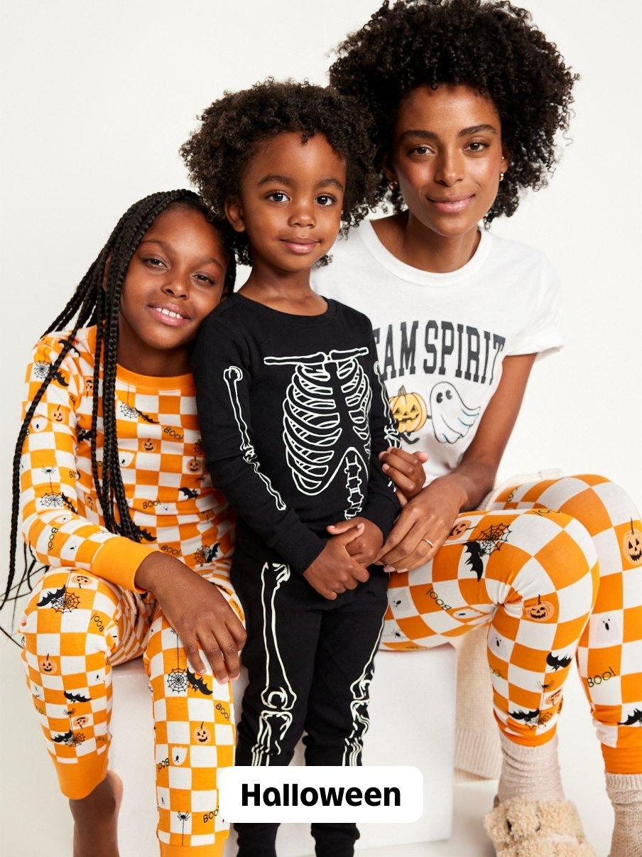 A mother and her children in halloween inspired spooky matching pjs.