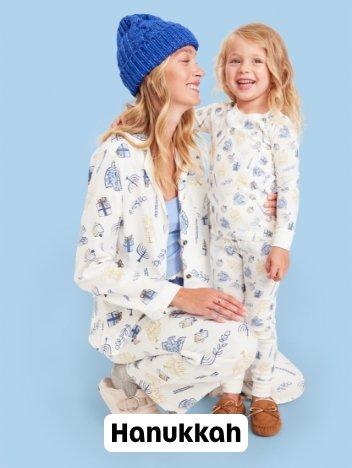 A mother and daughter in matching Hanukkah themed pjs.