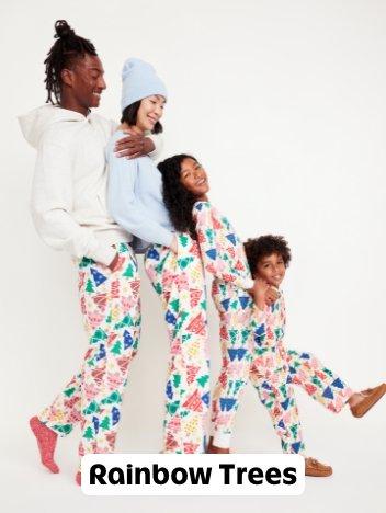 A family in matching rainbow holiday tree pajama pants.