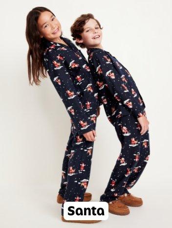 A boy and girl in matching santa print pjs.