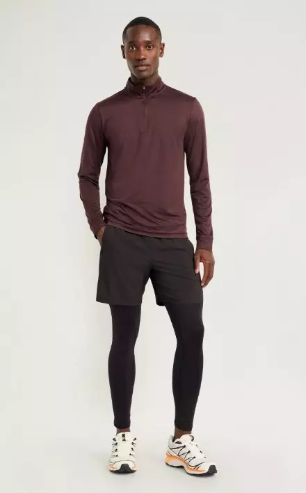 A male model wears a pair of activewear base layer bottoms.