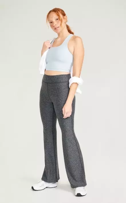 A female model wears High-Waisted CloudComfy Flare Leggings.