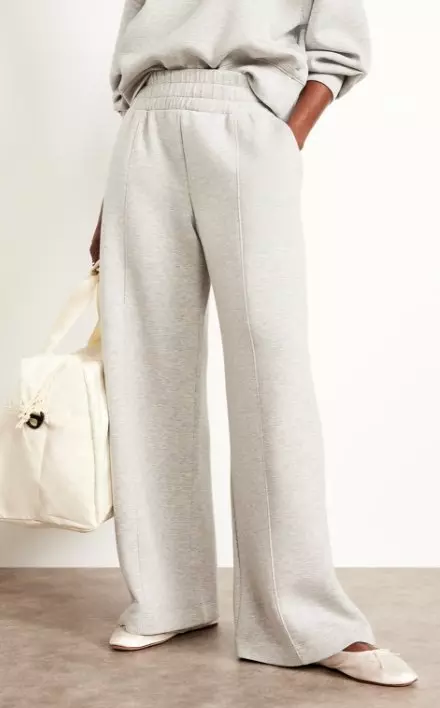 A female model wears High-Waisted Bounce Fleece Wide-Leg Pants.