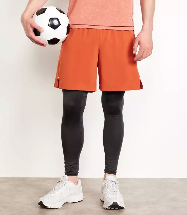 A male model wears dark base layer legging with shorts.