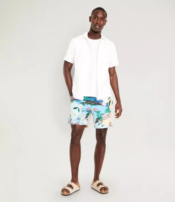 A male model wearing print swim 5" trunk and a basic t-shirt.