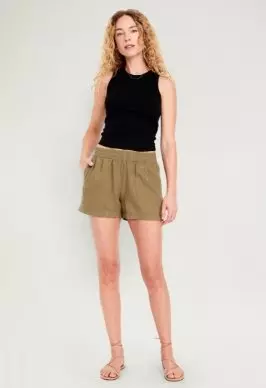 A female model wearing linen shorts.