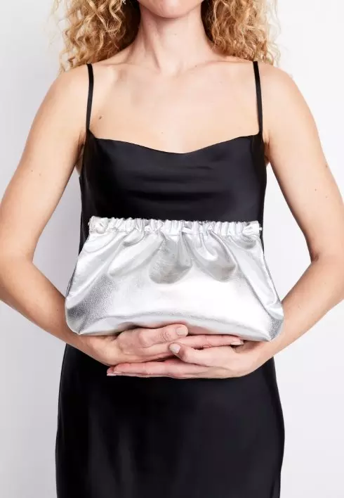 Image of a female model wearing a silver clutch.