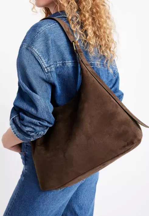 Image of a female model wearing a brown shoulder bag. 