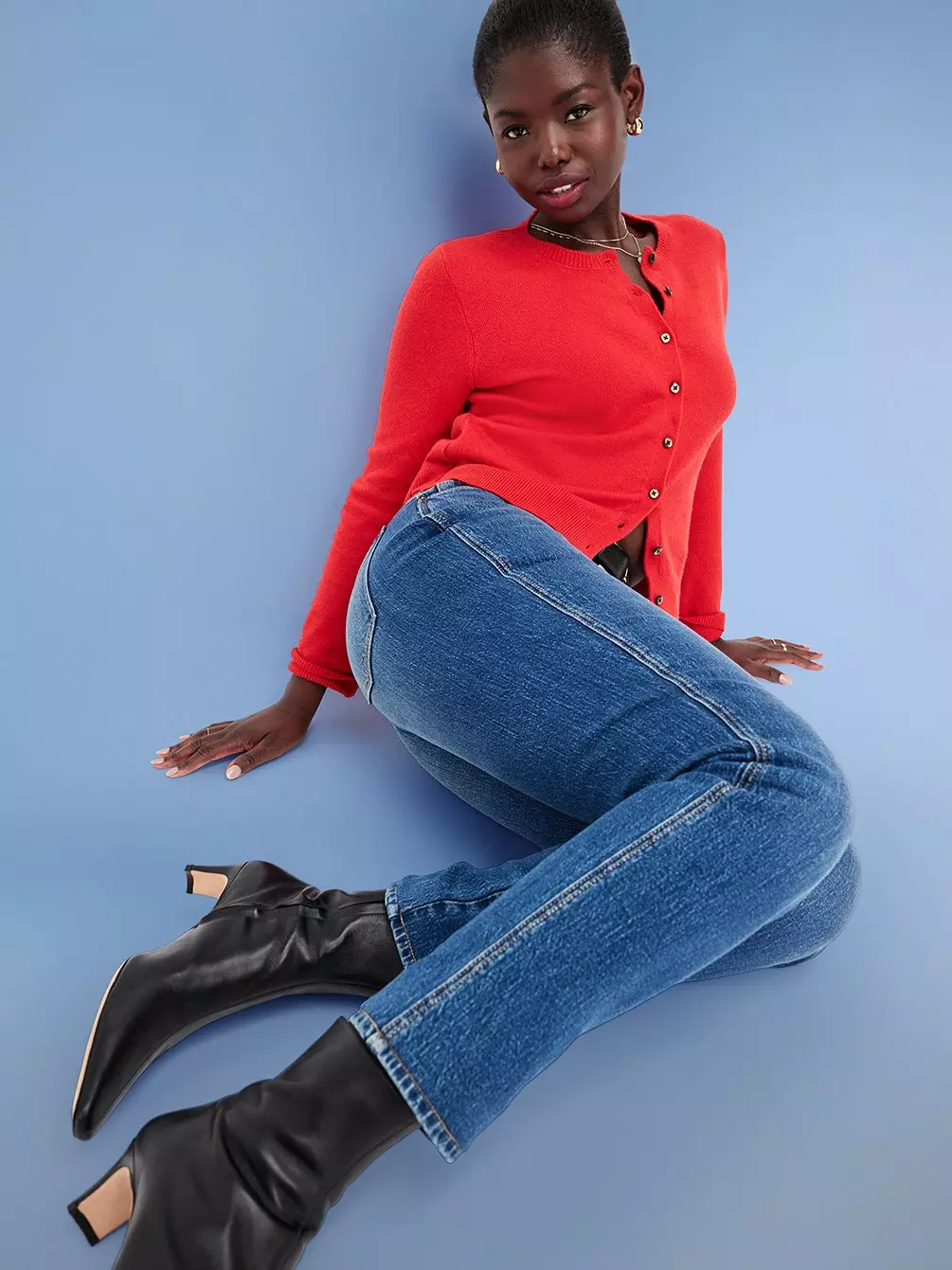 Image of a female model wearing Old Navy jeans, black boots and a red cardigan.