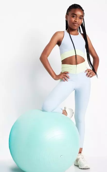 A young female model wears performance leggings and a matching sports bra.