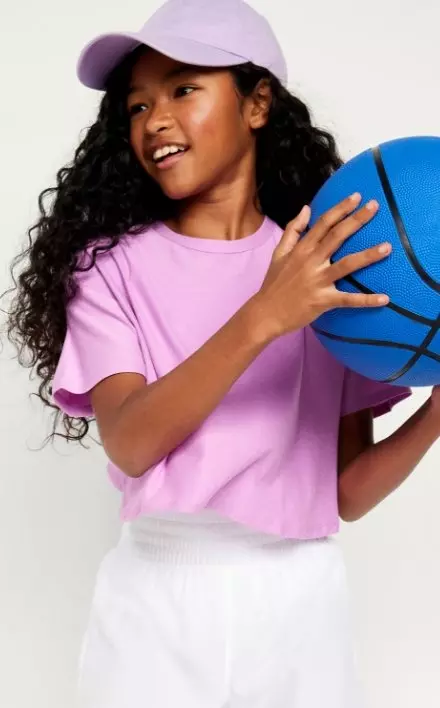 A young female model wears a performance T-shirt and baseball cap.