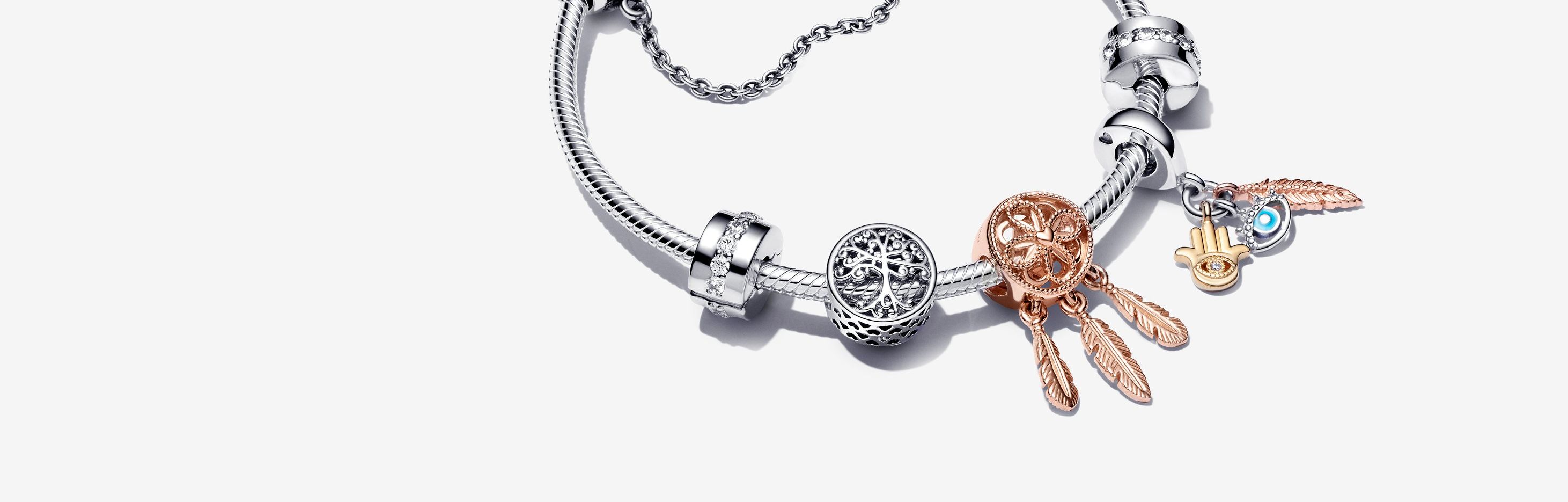 Armband i sterlingsilver med berlocker i silver och roséguld och en säkerhetskedja i silver