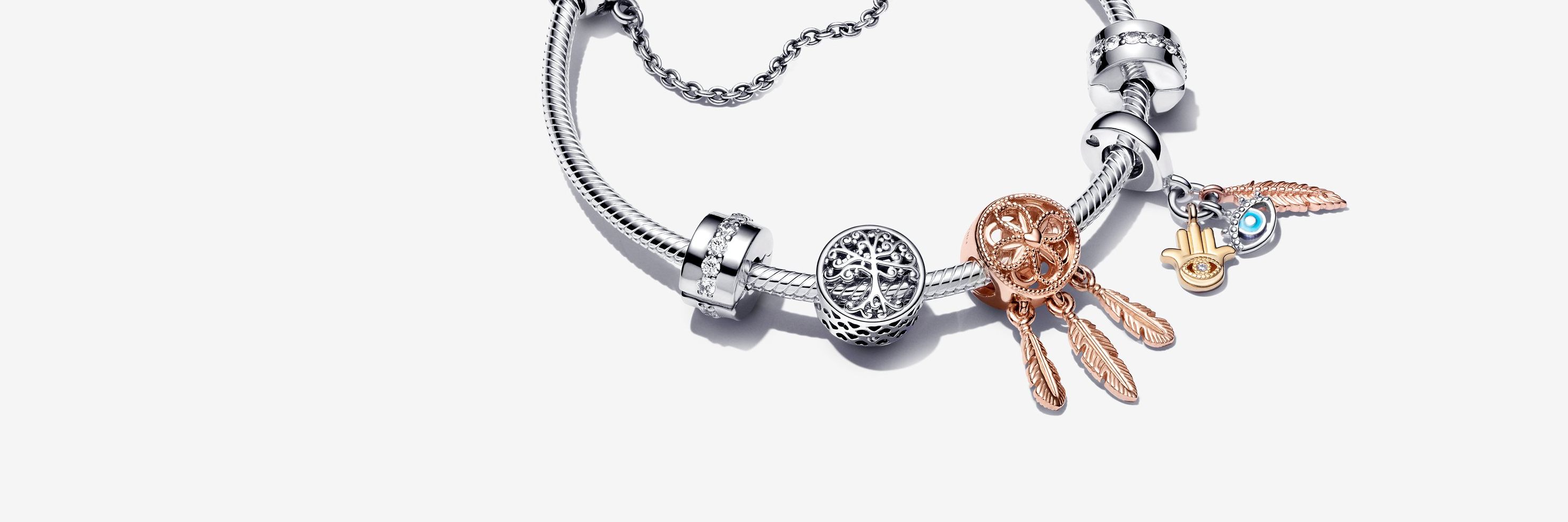 Sterling silver bracelet with silver and rose gold charms and a silver safety chain