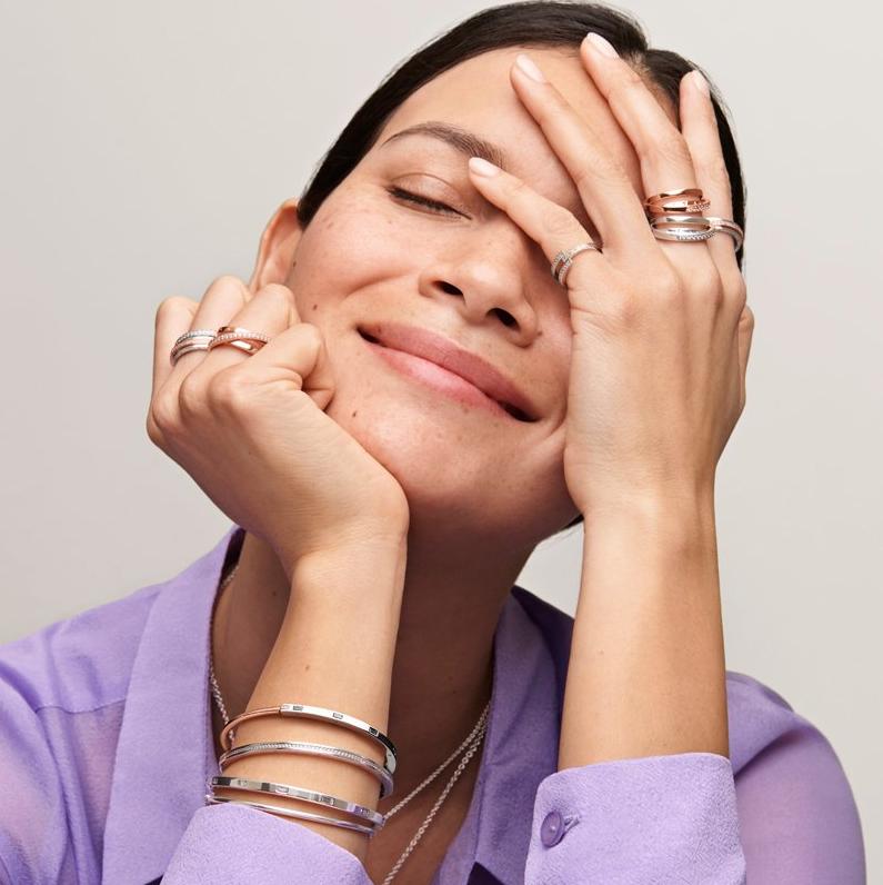 Woman in purple shirt wearing pandora signature stacking rings and bracelets