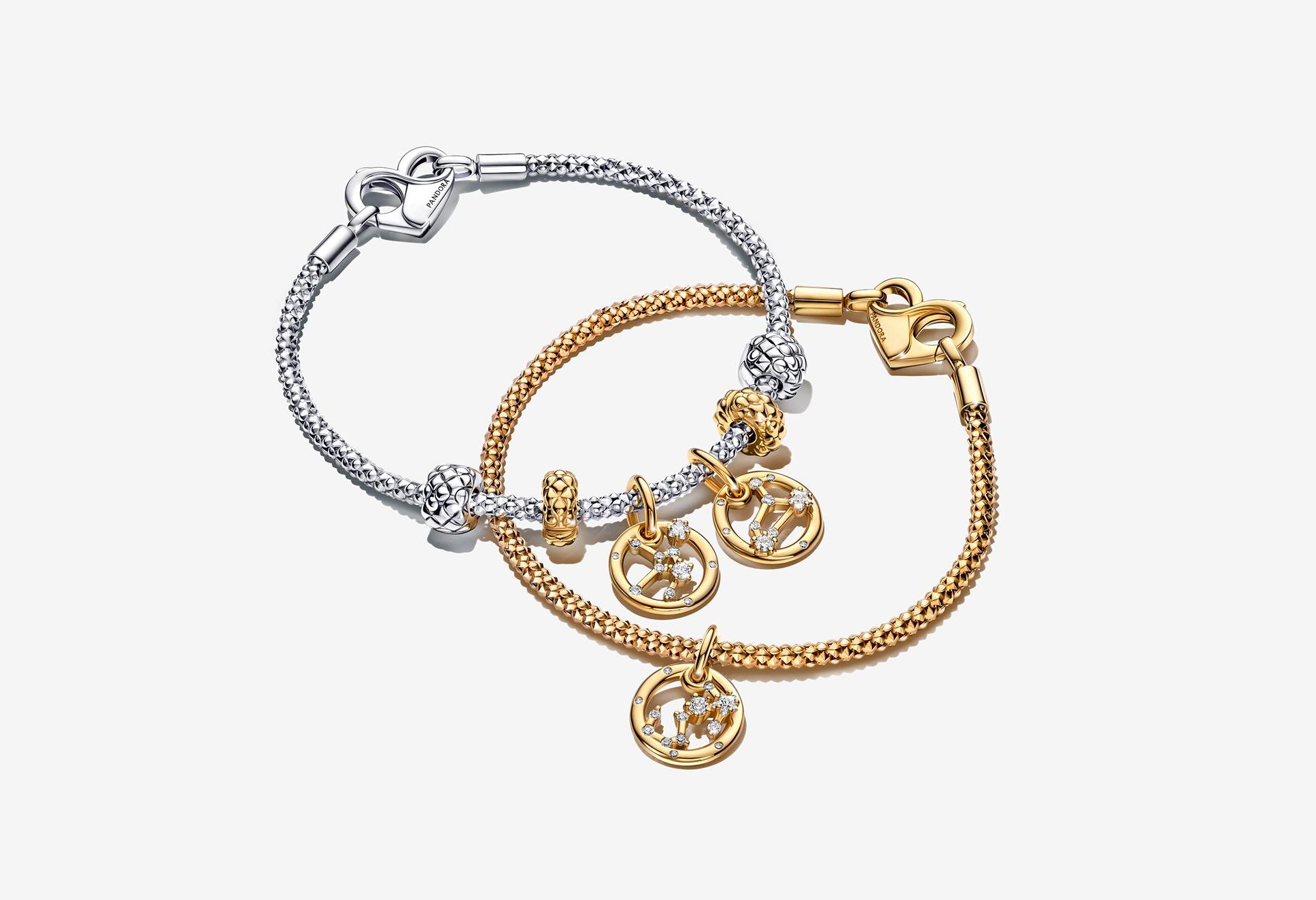 シルバーブレスレットの上に、ゴールドの Pandora Moments Zodiac Charm Bracelet を重ねづけした画像