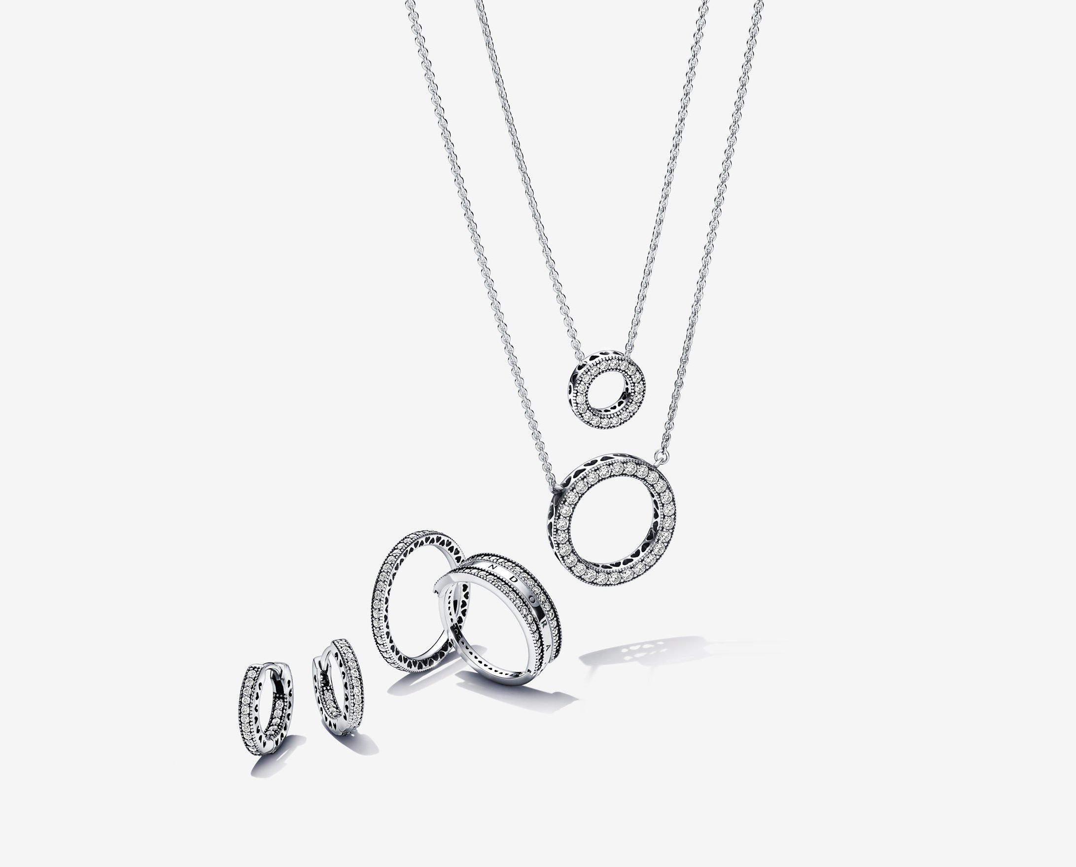 Bild von silbernen Halsketten, Ringen und Ohrringen aus der Signature-Serie von Pandora.