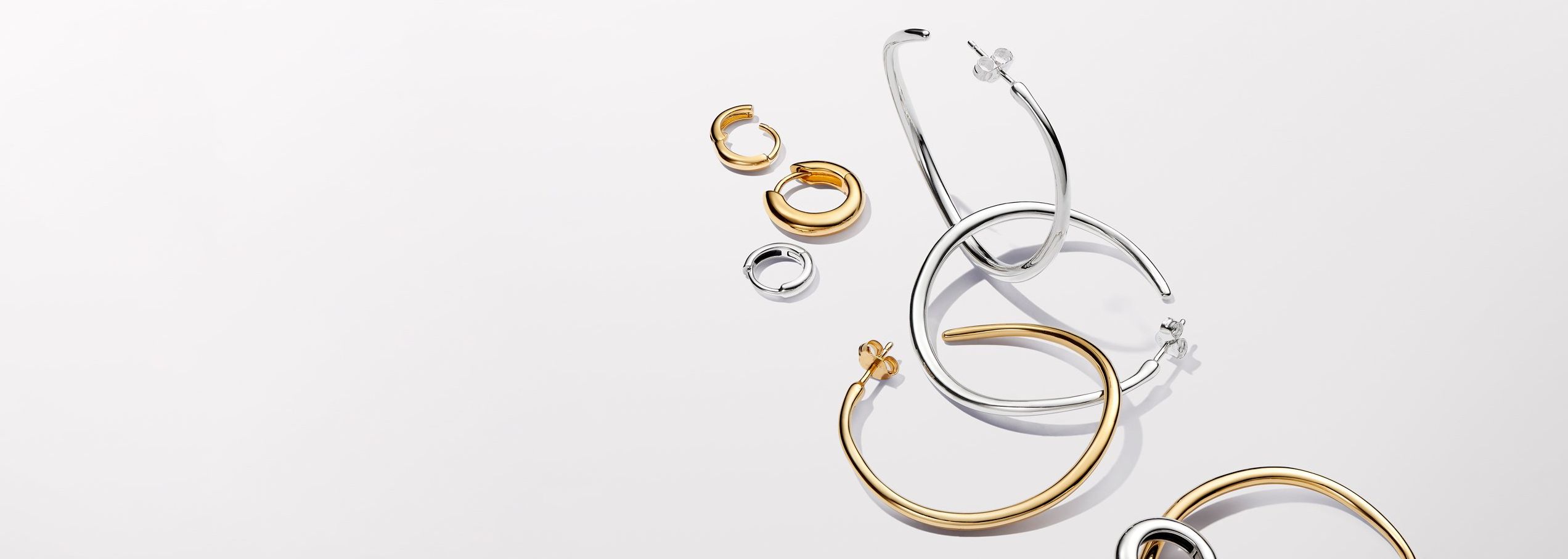 Pandora Essence gold and silver hoop earrings.
