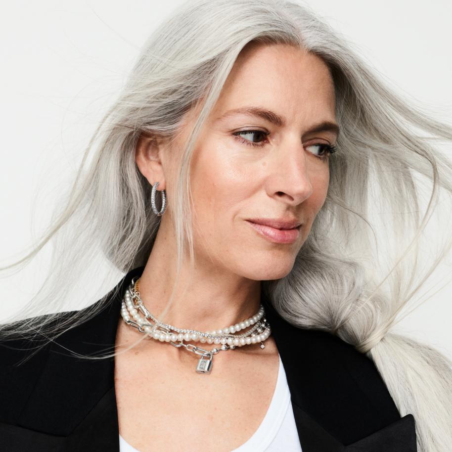 Sarah Harris, British Vogue's Editor-at-Large, wears a necklace stack of silver and pearl chains, with silver hoop earrings.