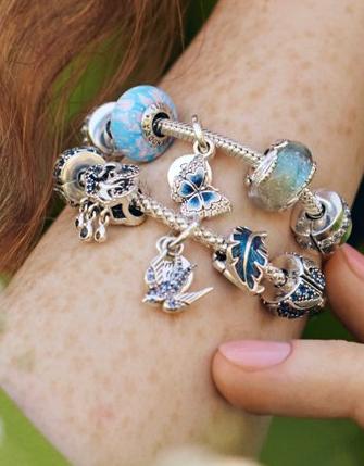 Model met Pandora Moments-lentebedelarmbanden met bloemen