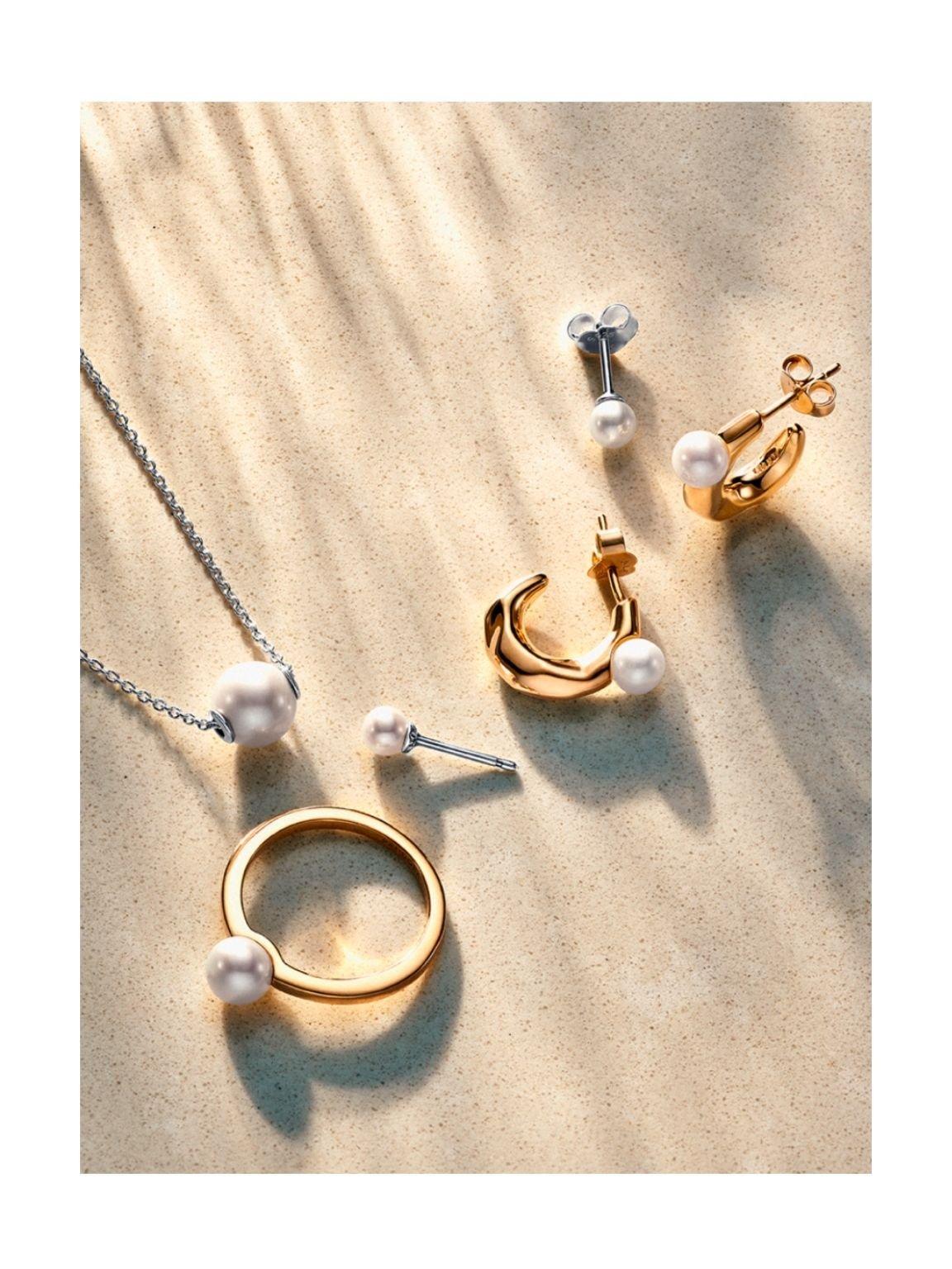 Pandora pearl earrings, necklace and ring on sunny sand