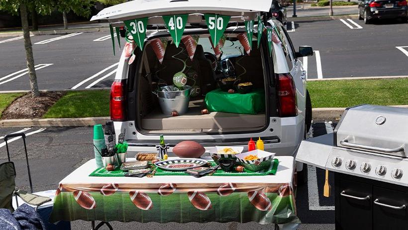 Tailgating out a mini van with food, drink, decorations and a grill