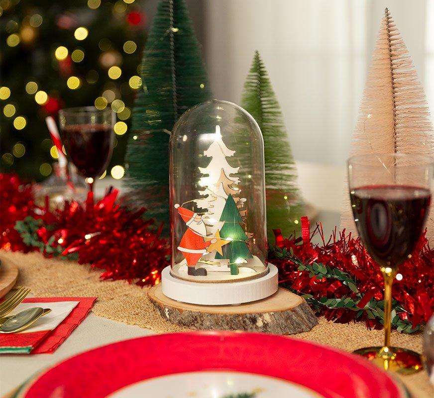 Christmas center piece with a snow globe like with Santa and tress, bottle brush trees and light up red garland