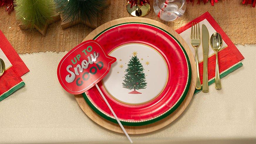 Festive plates with a Christmas tree and a photo booth prop