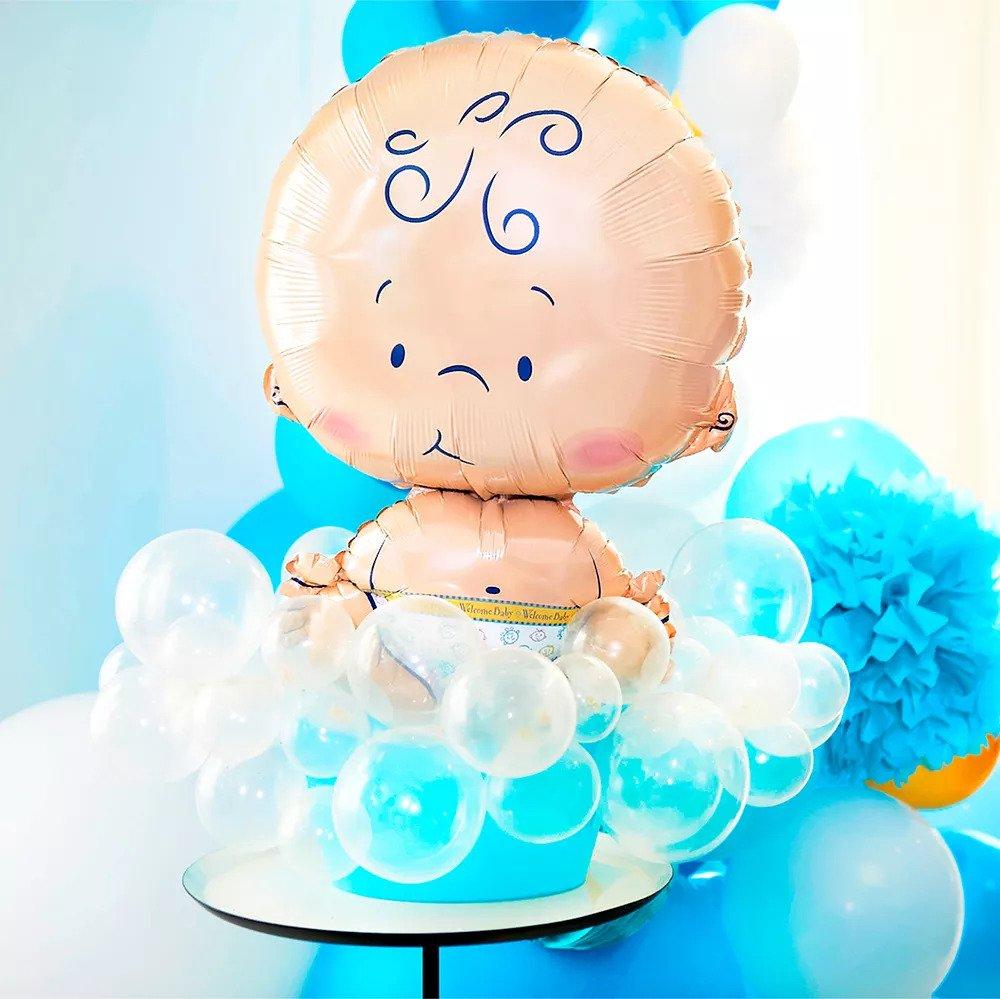 A baby-shaped balloon surrounded by clear latex balloons.