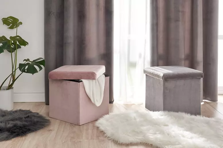 Pepco rózsaszín és szürke bársony tárolódobozok szőnyeggel és sötét függönyökkel berendezett lakótérben.