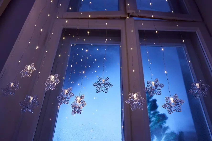 Pepco festive window display with snowflake decorations and string lights creating a magical winter atmosphere at dusk.